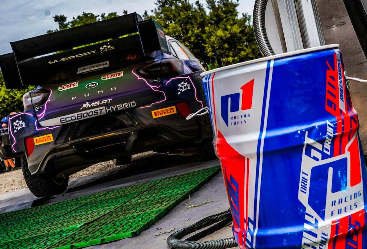 Back of a racing car next to a barrel of racing fuel